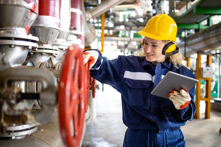 An experienced refinery or factory worker checking pressure of g